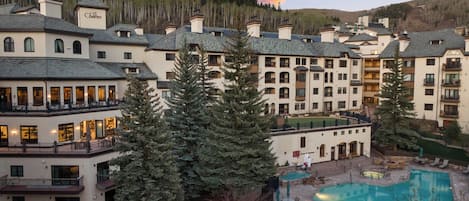 A resort with multiple buildings, a swimming pool, and surrounding trees.