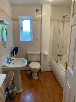 A bathroom with a pedestal sink, toilet, and bathtub.