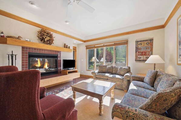 A living room with a fireplace, a television, and a sofa set.