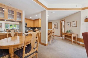 A spacious kitchen with wooden cabinets and a dining area with a wooden table and chairs.