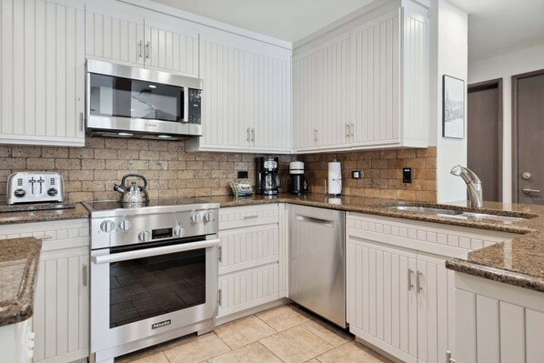A modern kitchen with white cabinetry, a Bosch microwave, a coffee maker, and a dishwasher.