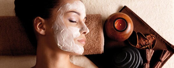 A person with a towel and a wooden bowl, suggesting a spa setting.