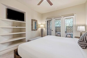 A hotel room with a large bed, a TV mounted on a wall, a desk with a lamp, and a balcony with a railing. - The Charter at Beaver Creek F120 (Beaver Creek)