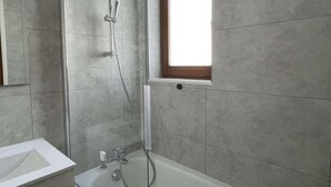 A bathroom with a shower, a bathtub, and a window. - 300m from resort center, 1st floor, balcony, parking, tv, ski locker, 28m², Praz sur Arly (Praz-sur-Arly)