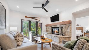 A modern living room with a fireplace, comfortable seating, and a ceiling fan. - The Charter at Beaver Creek E130 (Beaver Creek)