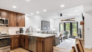 A modern kitchen with wooden cabinets, stainless steel appliances, and a central island. - The Charter at Beaver Creek E130 (Beaver Creek)