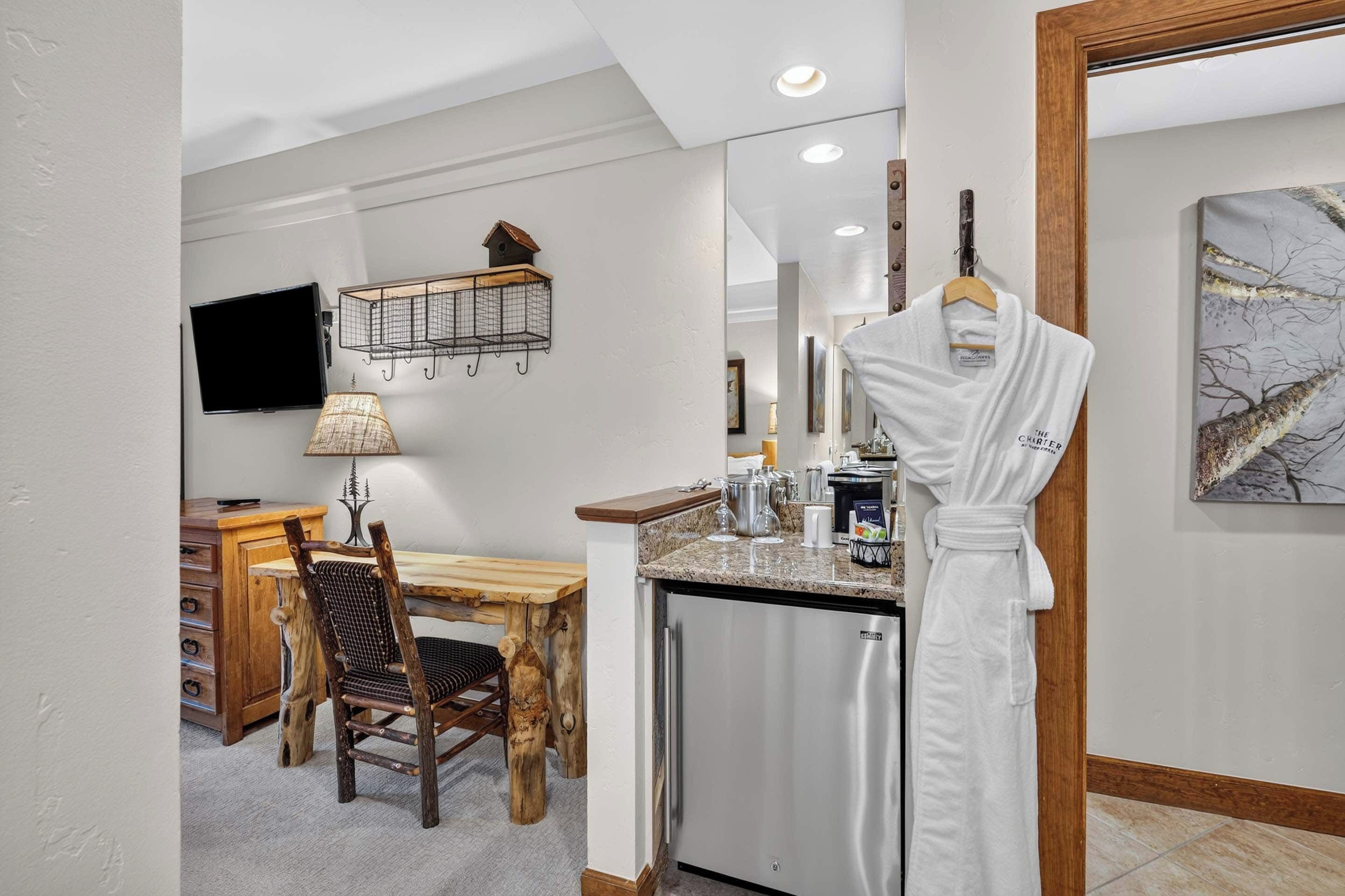 A hotel bathroom with a sink, mirror, and towel rack.