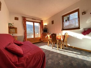 Enjoy a comfortable stay in this room featuring a cozy bed, dining area with table and chairs, and a television, with a view of the outdoors.
