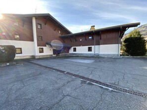 Guests can park their vehicles on the paved surface near the hotel building.
