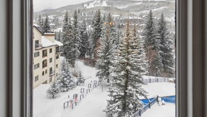 A snowy landscape with a building, trees, and a distant mountain. - The Charter at Beaver Creek D440 (Beaver Creek)