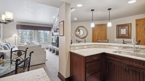 A modern kitchen with a large island, wooden cabinets, and pendant lighting. - The Charter at Beaver Creek D440 (Beaver Creek)