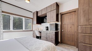 Ein Schlafzimmer mit Bett, Schreibtisch, Stuhl und Kleiderschrank.