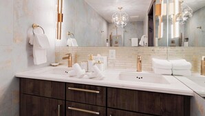 Ein modernes Badezimmer mit einem großzügigen Waschtisch, zwei Waschbecken und einem großen Spiegel.