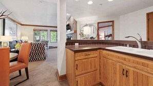 A modern kitchen with wooden cabinets, a large island, and a built-in oven.