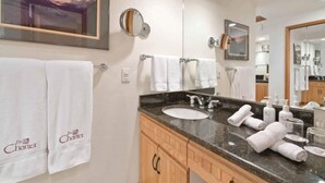 Une salle de bain avec un lavabo, un miroir et des serviettes.