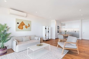 Ein modernes Wohnzimmer mit einer Couch, einem Couchtisch und einem Essbereich mit Stühlen.