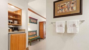 A hallway with a wooden cabinet, a bench, and a framed picture on the wall. - The Charter at Beaver Creek C035 (Beaver Creek)