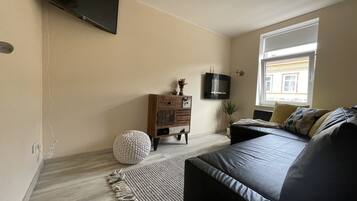 Relax in this serene bedroom with a large bed, sofa, and dresser, perfect for unwinding.