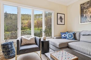 A living room with a sofa, armchair, and a chessboard. - The Charter B310 - 2 Bedroom (Beaver Creek)