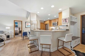 A modern kitchen with a central island, wooden cabinets, and stainless steel appliances.