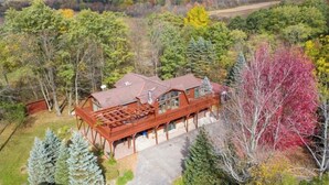 Une cabane en bois dotée d’une terrasse, entourée d’arbres et offrant une vue sur un ciel dégagé.