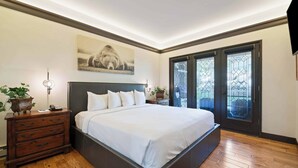 Un dormitorio con una cama grande, cómoda de madera y un cuadro en la pared.