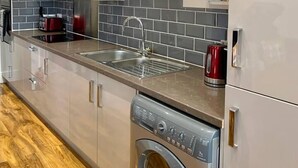 A modern kitchen with stainless steel appliances, a built-in oven, and a dishwasher. - Inviting 1-bed Apartment in Lytham Saint Annes (Lytham St. Anne's)
