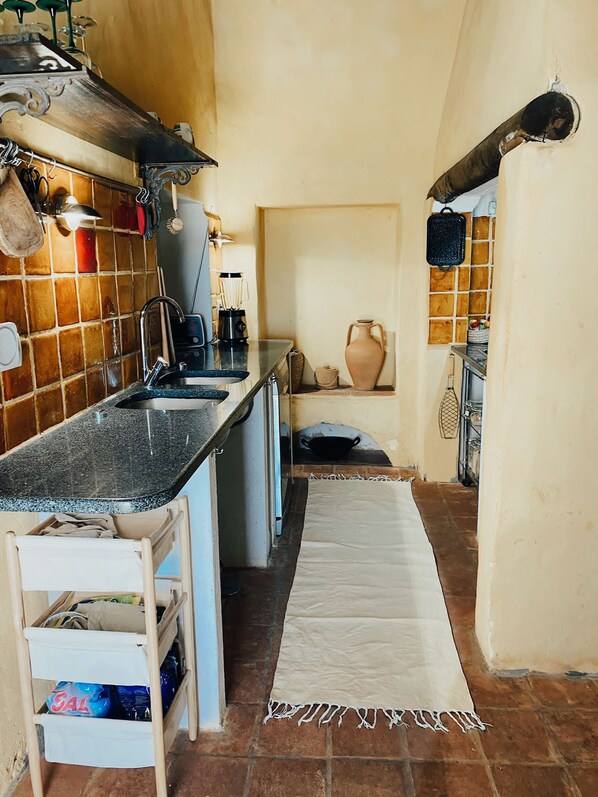A compact kitchen with a sink, stove, and various utensils.