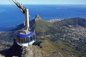 A cable car system with a clear view of a coastal town and surrounding hills. - Amazing 2 Bedroom Apartment With Mountain Views on Kloof Street (Cape Town)