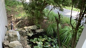 A wooden deck with a stone wall and water feature. - Amazing view from the Family Lake Retreat (Murphy)