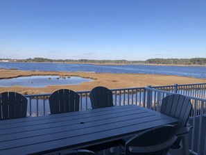 A deck with a table and chairs overlooking a body of water and marshland. - Townhome: Unbeatable Views of Little Assawoman Bay (Selbyville)