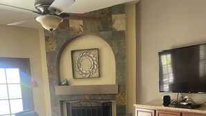 A living room with a fireplace, a television, and a sofa. - North Phoenix Close to Everything/ Secured Parking (Glendale)
