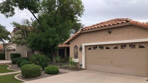 A residential house with a beige facade, a tiled roof, and a garage. - North Phoenix Close to Everything/ Secured Parking (Glendale)