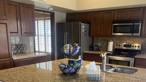 A kitchen with granite countertops, stainless steel appliances, and wooden cabinets. - North Phoenix Close to Everything/ Secured Parking (Glendale)