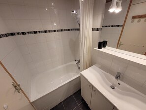 Ein Badezimmer mit Badewanne, Waschbecken und Spiegel.