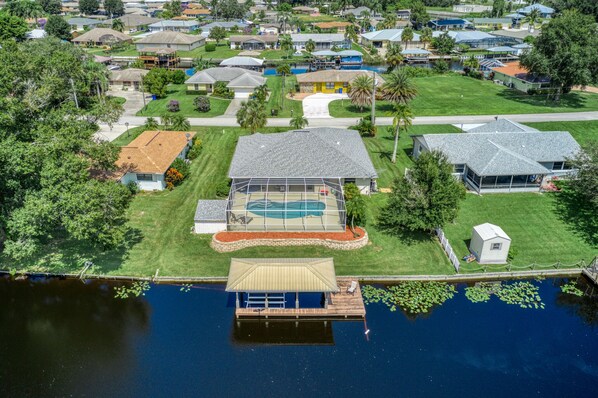 An aerial view of a residential area with a large house featuring a swimming pool, a dock, and a small shed. - Welcome to Floridays...a quiet place by the lake (Lake Placid)