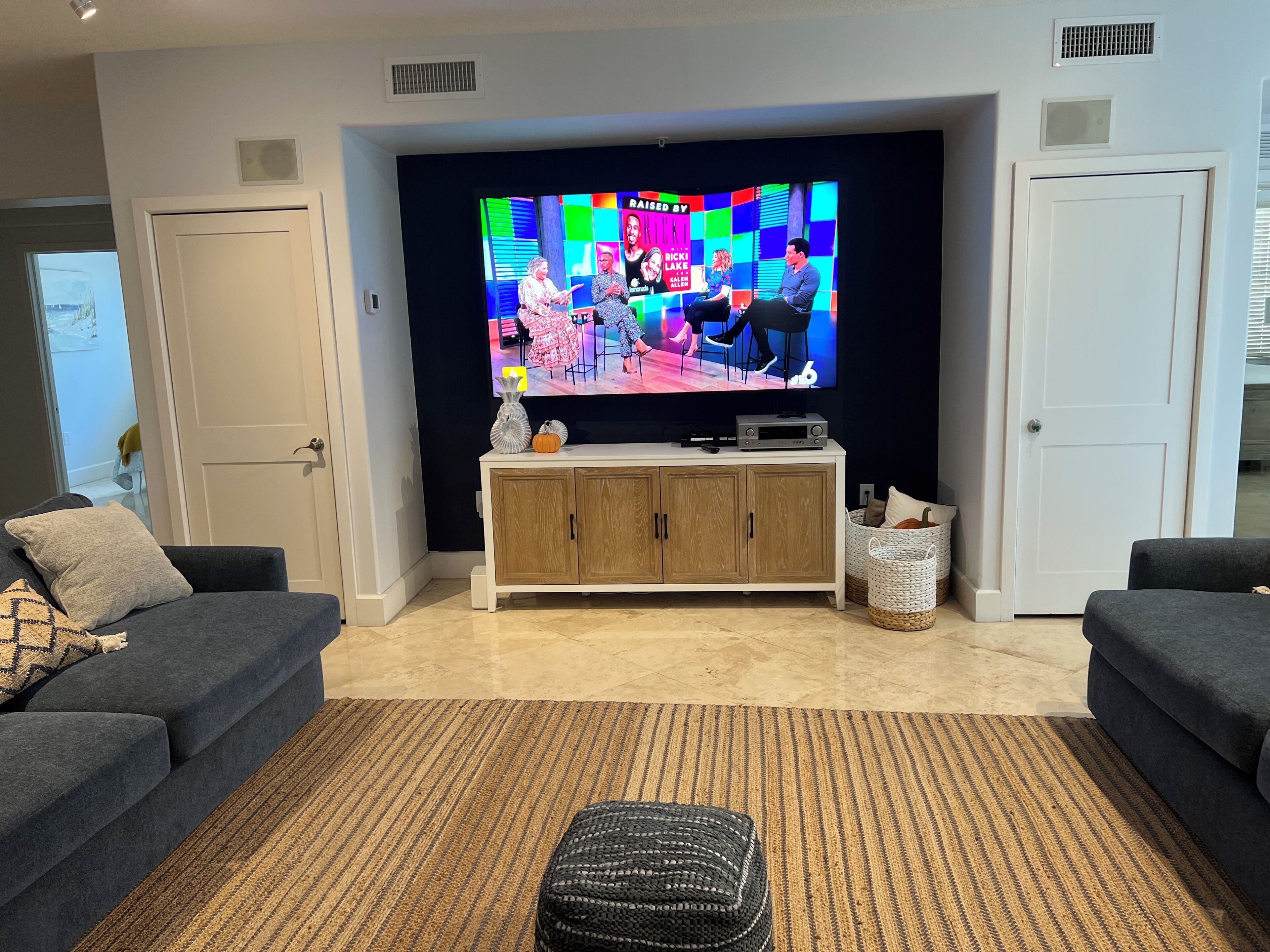 A living room with a flat-screen TV, two sofas, a coffee table, and a cabinet.