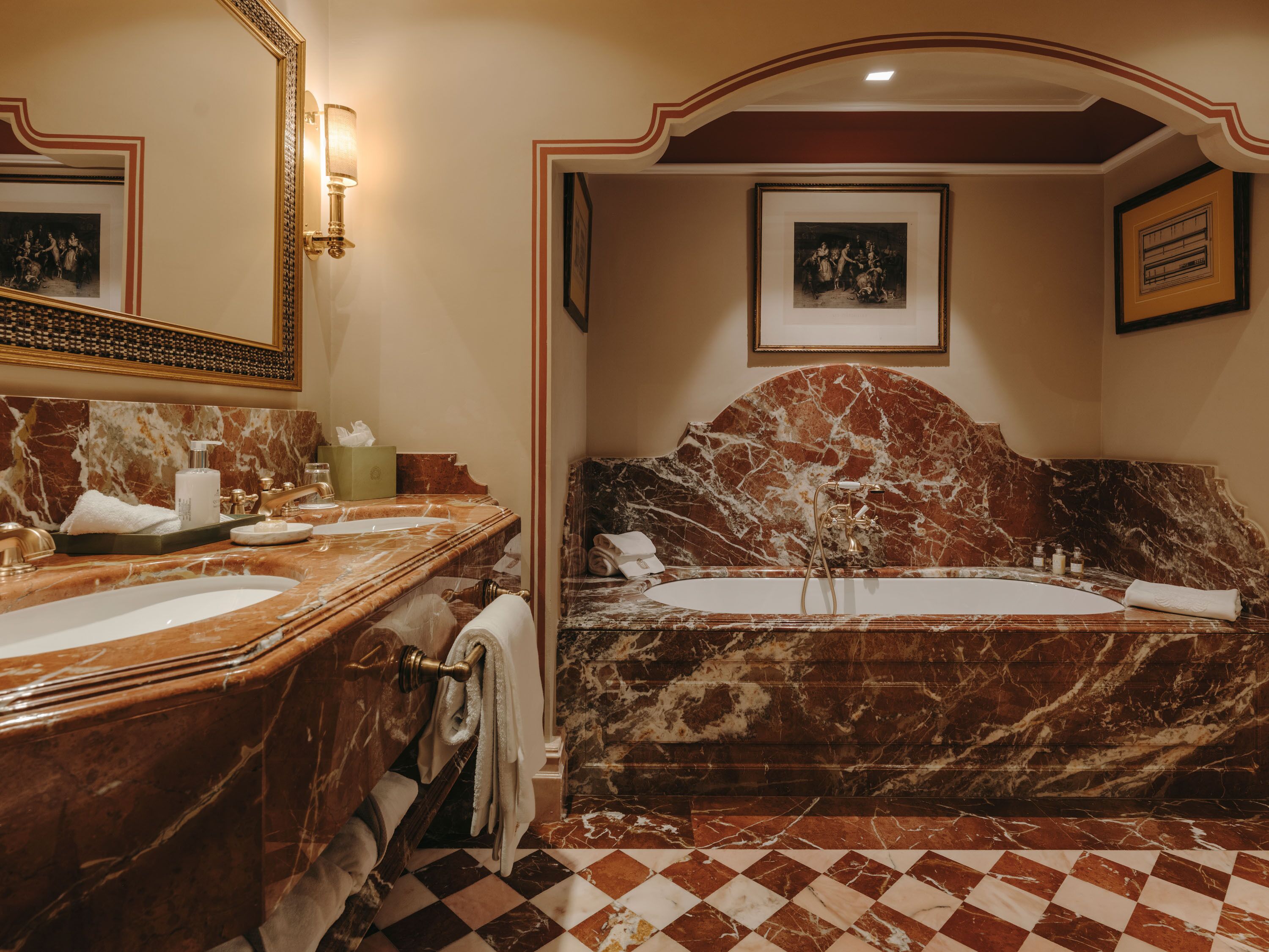 Ein luxuriöses Badezimmer mit Marmorwaschtisch, einer großzügigen Badewanne und einer separaten Duschkabine.