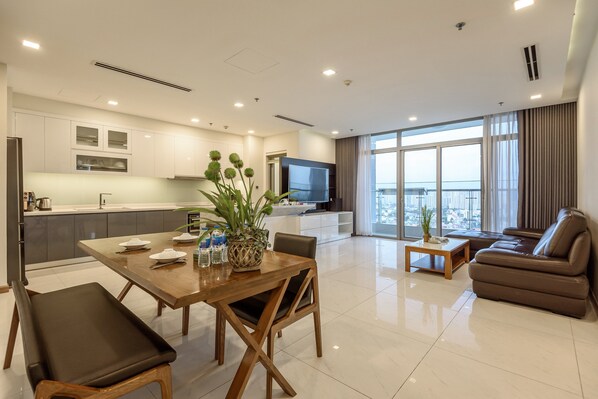 Una sala moderna con comedor, sofá y televisor.