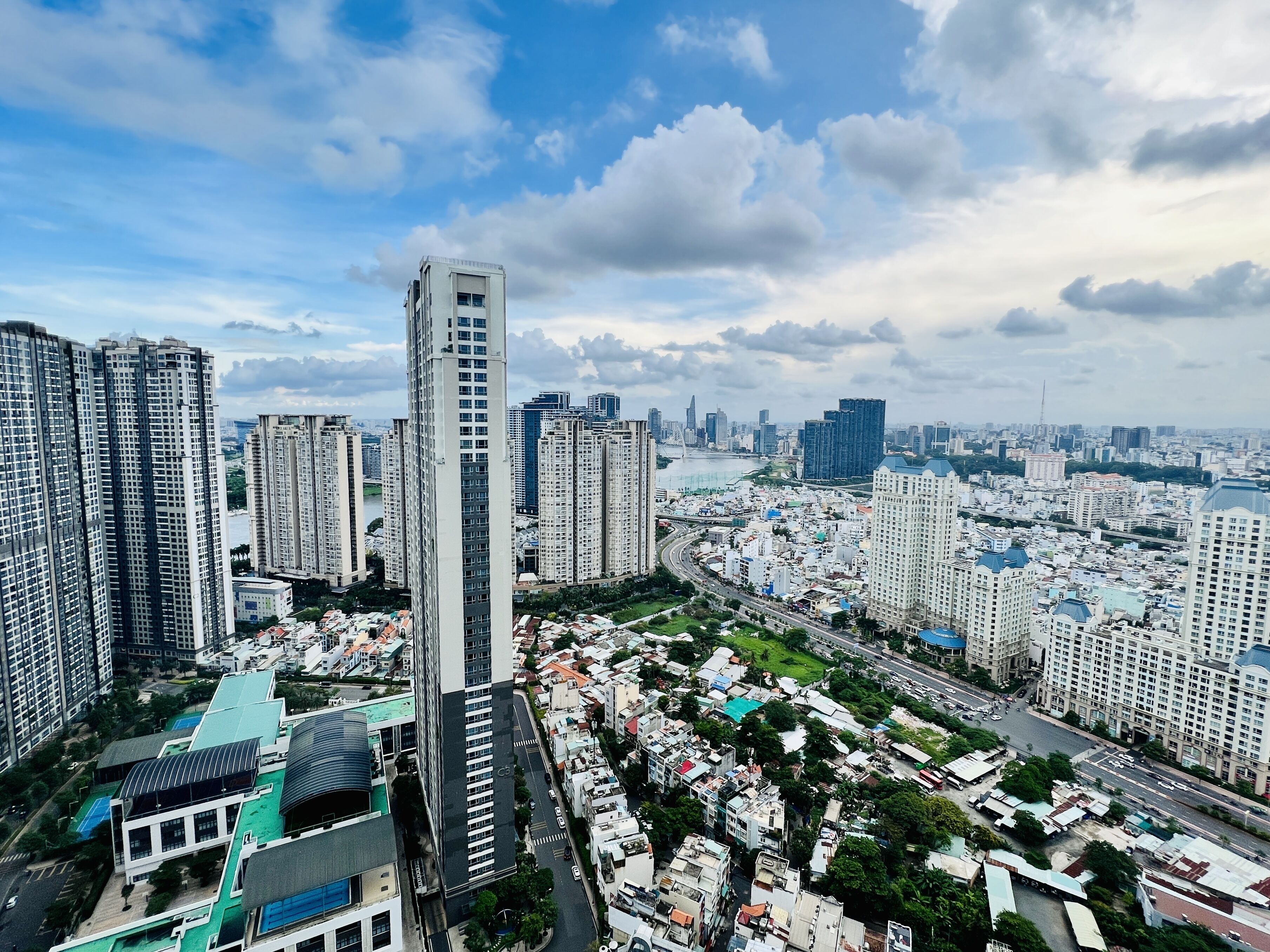 A high-rise building with a modern design, surrounded by other high-rise buildings and a mix of residential and commercial structures.