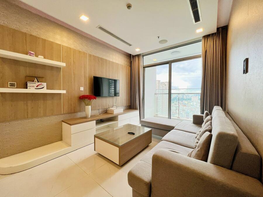 A modern living room with a sofa, a coffee table, and a TV mounted on the wall.