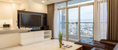 Una sala de estar moderna con un televisor grande, un sofá y una mesa de comedor.