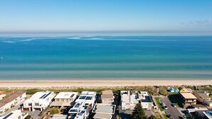 Un quartier résidentiel en bord de mer, avec des maisons modernes, une plage et une vue sur l’océan.