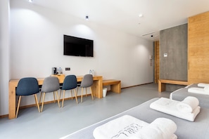 Relax in comfort with a flat-screen TV, desk, and bench, plus a cozy bed with fresh towels.
