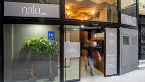 A hotel entrance with a sign reading "nalu Valencia Boutique Rooms" and a potted plant outside. - Nalu Valencia Boutique Rooms (Valencia)