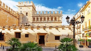A historic building with a prominent tower and a courtyard with potted plants. - Nalu Valencia Boutique Rooms (Valencia)