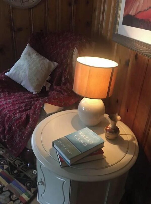 A cozy room with a bed, a bedside table with a lamp, and a book. - Woodland Oasis Cabin Apartment (Youngstown)