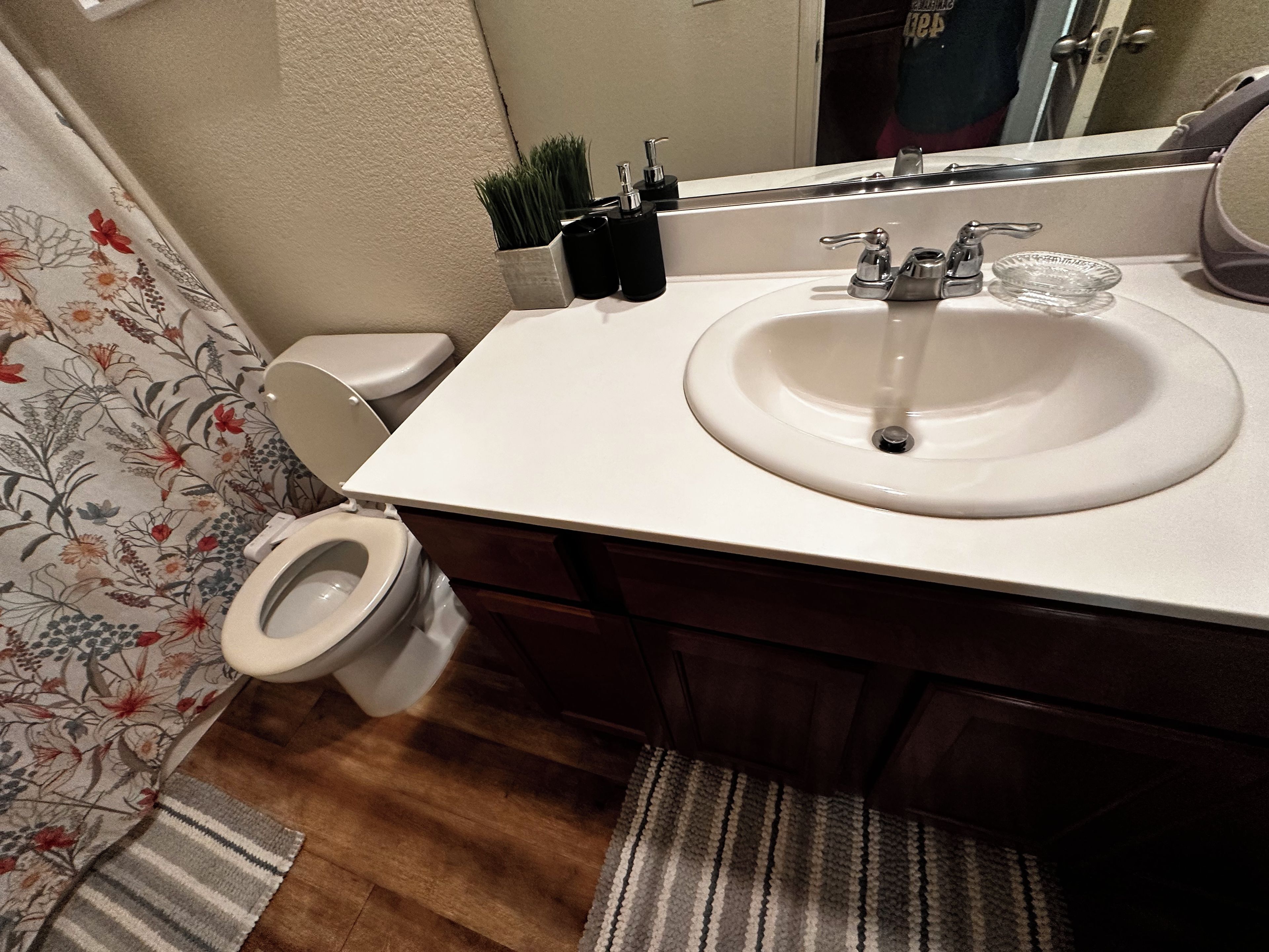 Ein Badezimmer mit Toilette, Waschbecken und Spiegel.