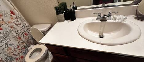Ein Badezimmer mit Toilette, Waschbecken und Spiegel.