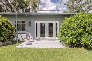 Enjoy a serene atmosphere surrounded by lush greenery and a patio area with comfortable seating.